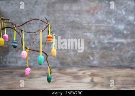 Easter dekorative eggs on tree branches.   Easter tree in vase with colorful eggs on a grey rustic background Stock Photo