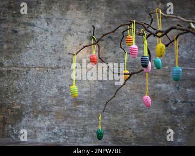 Easter dekorative eggs on tree branches.   Easter tree in vase with colorful eggs on a grey rustic background Stock Photo