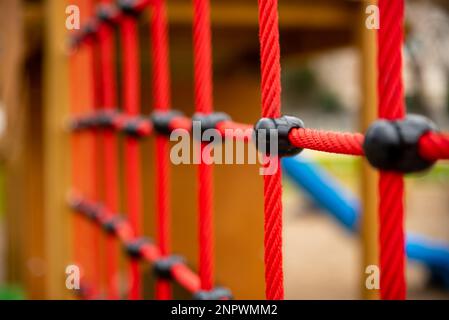 climbing net in children's playground , red rope Childrens playground in the city park. , . High quality photo Stock Photo