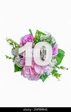 Number ten shape with bunch of flowers isolated over white background. Summer concept. Flat lay. Top view Stock Photo