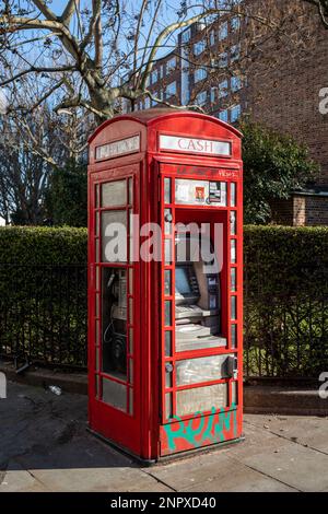 Old traditional telephone booth converted into a cashpoint or an ATM and modern payphone on Portobello Road of Notting Hill, London, England Stock Photo