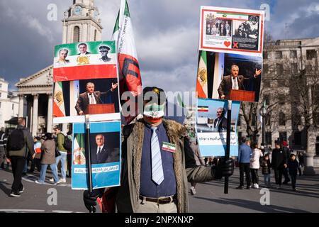 London, UK. 25th Feb, 2023. A protester holds up signs in support of the freedom in Iran during the demonstration march. Following the first anniversary of Russia-Ukraine War, protest groups gathered in Central London and marched to Trafalgar Square, calling for peace in Ukraine and Iran. Credit: SOPA Images Limited/Alamy Live News Stock Photo