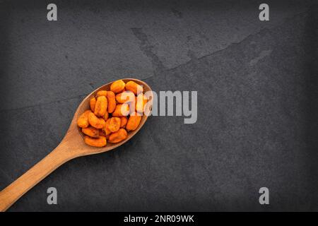 Crunchy salty chili corn - Zea mays. Toasted snacks on the spoon Stock Photo