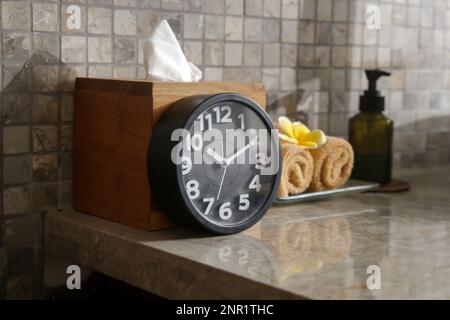 Spa items in beauty spa salon, clock, towels and cosmetic product bottle on the table Stock Photo