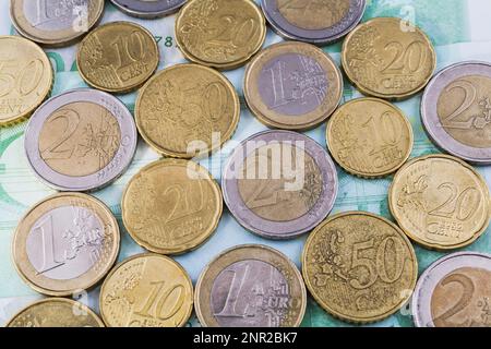 Various Euro coins on top of 100 Euro bank notes. Stock Photo