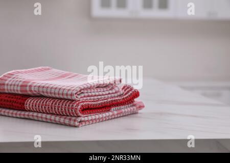 Stack of kitchen towels on white marble table. Space for text Stock Photo
