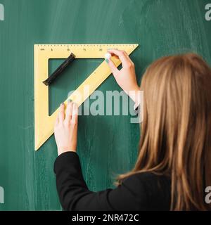 woman drawing with triangular ruler blackboard Stock Photo