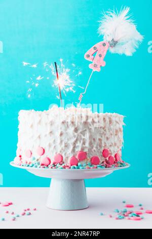 fourth birthday cake with burning sparkler white surface Stock Photo