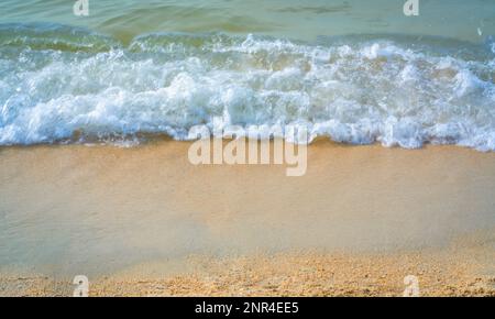 Ocean wave with foam on clean sandy beach. Nature background concept. Stock Photo