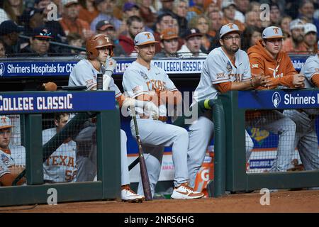 Texas Longhorns assistant coach Troy Tulowitzki (second from left) and Texas  Longhorns student assistant Huston Street (second from right) watch the  action from the dugout during the game against the LSU Tigers