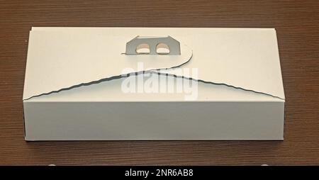 Closed cardboard white cake box on wooden table Stock Photo