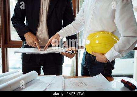 Team of architect and engineer working and discussing about new startup project on desk. Architect discuss with engineer about project  in office. Stock Photo