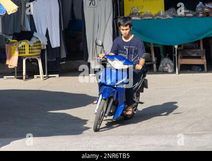 SAMUT PRAKAN, THAILAND, FEB 13 2023, A young man rides a motorcycle at market Stock Photo