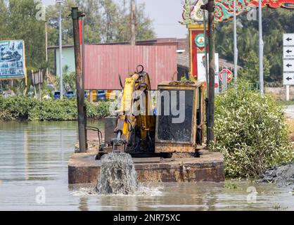 A floating dredger is dredging the bottom of the pond, Thailand Stock Photo