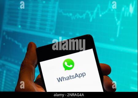 China. 15th Feb, 2023. In this photo illustration, the encrypted instant messaging application owned by Meta Platforms and formerly known as Facebook, and WhatsApp, a logo is seen displayed on a smartphone with an economic stock exchange index graph in the background. (Credit Image: © Budrul Chukrut/SOPA Images via ZUMA Press Wire) EDITORIAL USAGE ONLY! Not for Commercial USAGE! Stock Photo