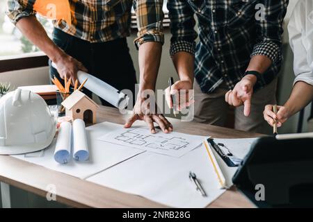 People adviser construction site engineers. working drawing on blueprint and discussing the floor plans over blueprint architectural plans at on Stock Photo