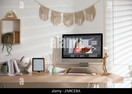 Designer's workplace. Computer with photo editor application on table indoors Stock Photo