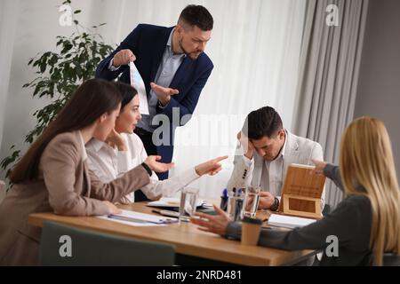 Boss scolding employee at workplace in office Stock Photo