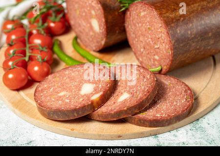 Beef sausage with cheddar. Raw grilled sausage on a wood serving board. Deli products. Close up Stock Photo