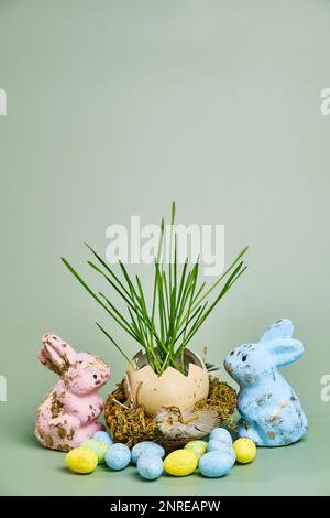 Happy easter day on april, Easter eggs and candy bunny, natural egg with growing wheat in the nest. Selective focus. Copy space. Zero waste concept Stock Photo
