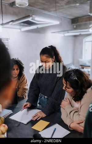 Young businesswoman discussing strategy with female colleagues while working in office Stock Photo