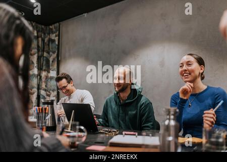 Happy multiracial business colleagues discussing in meeting at workplace Stock Photo