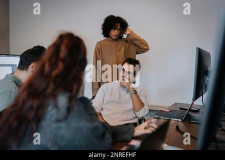 Multiracial female and male computer programmers discussing in startup company Stock Photo