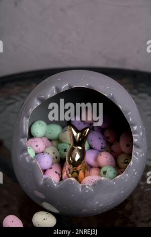 photo a lot of colored Styrofoam eggs lying in a large gray egg with a rabbit inside Stock Photo