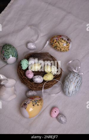 photo on a white tablecloth with lots of decorative eggs and a white Easter bunny view over Stock Photo