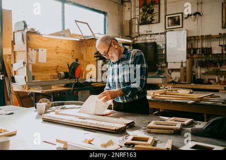 Craftsman examining documents at carpentry workshop Stock Photo