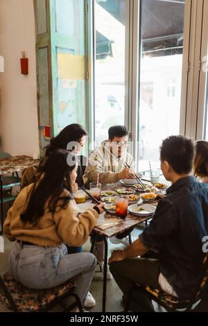 Male and female friends having lunch together at restaurant Stock Photo