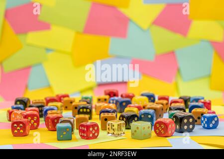 colourful dices on a table with multicolored paper sticky notes on background Stock Photo