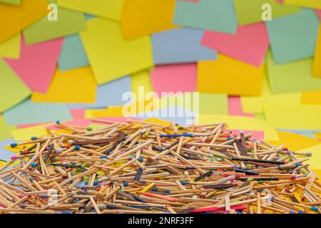matchsticks of various shapes and colors with multicolored paper sticky notes on background Stock Photo