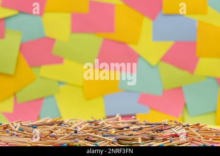 matchsticks of various shapes and colors with multicolored paper sticky notes on background Stock Photo