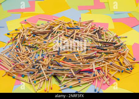 matchsticks of various shapes and colors with multicolored paper sticky notes on background Stock Photo