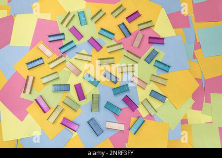 Multicolored office metal staples for stapler on multicolored paper Sticky Notes Stock Photo