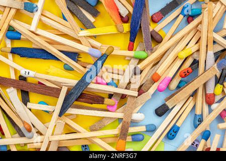 matchsticks of various shapes and colors with multicolored paper sticky notes on background Stock Photo