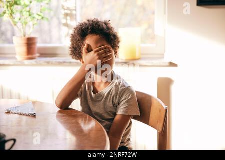 Boy covering eyes with hands Stock Photo - Alamy
