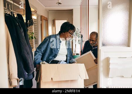 Happy senior couple helping each other while cleaning home Stock Photo