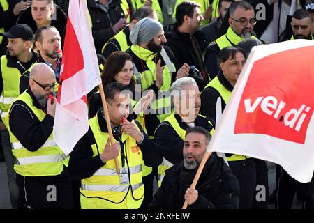 Duesseldorf, Germany. 27th Feb, 2023. Striking airport employees stand with Verdi flags in the airport terminal. The Verdi trade union has called on its members to go on warning strikes at airports in North Rhine-Westphalia and in the public sector. Credit: Federico Gambarini/dpa/Alamy Live News Stock Photo