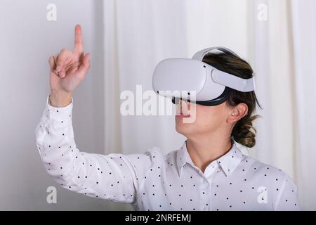 Young woman gesturing in virtual reality headset. Stock Photo
