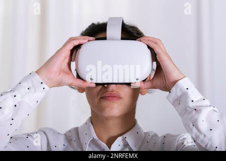 Hands of young woman holding virtual reality glasses, user experience. Stock Photo