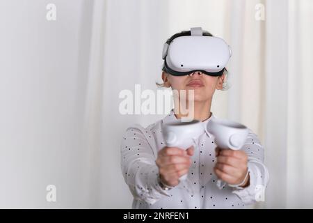 Woman with vr glasses and controls in her hands. Stock Photo