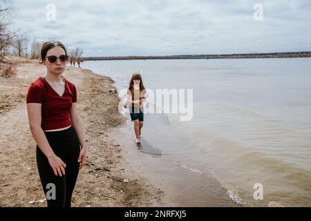 unhappy teen girl standing next to lake Stock Photo