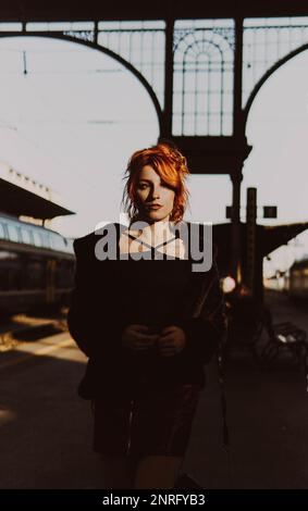 red-haired woman in train station Stock Photo