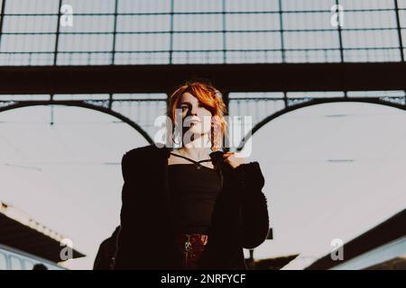 red-haired woman in train station Stock Photo