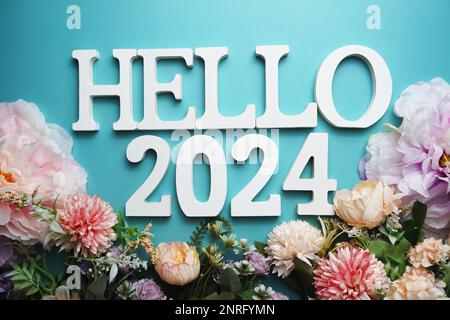 Hello 2024 alphabet letter with flower decoration on blue background Stock Photo