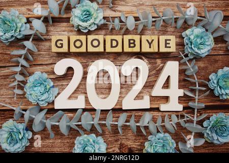 Goodbye 2024 alphabet letters with flower decorate on wooden background Stock Photo