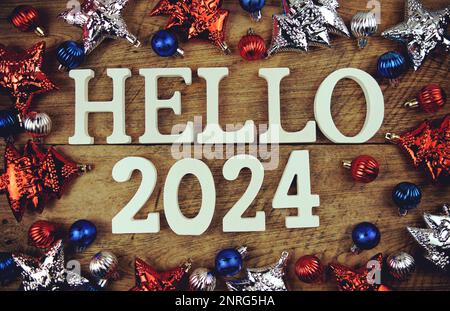 Hello 2024 alphabet letters with christmas decoration on wooden background Stock Photo