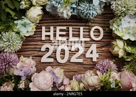 Hello 2024 alphabet letters decorate with flowers on wooden background Stock Photo